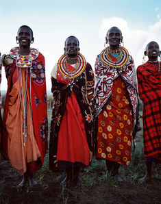 four african women in colorful clothing standing together