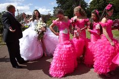 a group of women in pink dresses standing next to each other