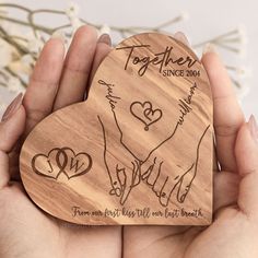 two hands holding a wooden heart shaped ornament that says together since we have lost hearts