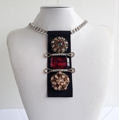 Each piece of our statement necklaces is handmade and one of a kind made in Italy. Our creations is made of high quality materials such as crystals and rhinestones. Each embroidered material is carefully hand sewn. Very glamorous and stylish. Perfect gift to someone you like. Materials Jeweled  elements and Marbled Red stones in different shape and dimension.  Application on black gross grain ribbon with gross grain ribbon backing. Aluminium chain with lobster closure. Measurements Weight approximate 150 grams. Chain lenght 45 cm - 17,71 in Jewel Tie lenght 14 cm - 5,51 in Feel free to contact us if you have any question. Thank you so much for looking at our shop and our articles each of them, single piece. Party Crystal Pendant Necklace With Rhinestones, Rhinestone Jeweled Choker Necklace, Luxury Crystal Embellished Metal Necklaces, Rhinestone Jewel Choker Necklace, Costume Jewelry Rhinestone Pendant Necklace For Party, Luxury Crystal Embellished Metal Necklace, Crystal Chain Necklaces For Evening, Crystal Necklaces With Chain For Evening, Jeweled Pendant Rhinestone Necklace