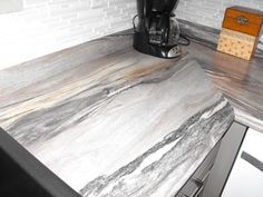 a kitchen counter with marble top and white cabinets