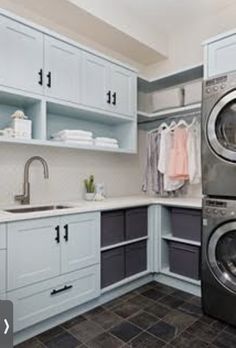 a washer and dryer sitting in a kitchen next to cabinets with open shelving