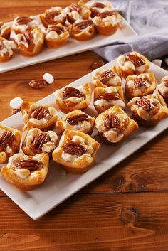 two white plates filled with mini pecans and marshmallows on top of a wooden table