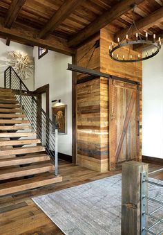 a wooden staircase leading up to the second floor in a home with wood paneling and metal railings