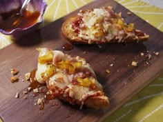 two slices of pizza sitting on top of a wooden cutting board