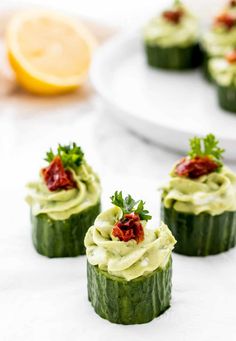 small cucumbers with cream cheese and garnish on them