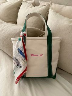 a white tote bag sitting on top of a bed