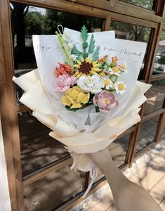 a person holding a bouquet of flowers in front of a glass door with the words you are my sunshine written on it