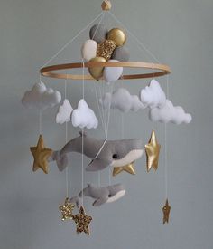 a mobile that has some stuffed animals hanging from it's sides and stars on the strings