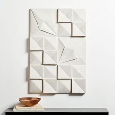 a wooden bowl sitting on top of a black table next to a white tile wall