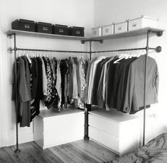 an organized closet with clothes hanging on the rails and drawers in black and white photo