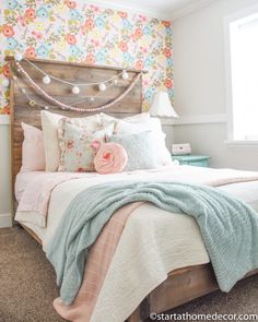 a bedroom with floral wallpaper and wooden headboard