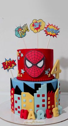 a spiderman birthday cake with the number four on it's top and decorations