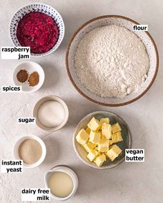 ingredients to make raspberry jam laid out in bowls on a white table top