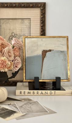 a vase filled with flowers sitting on top of a table next to an old book