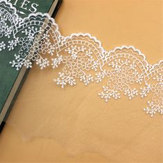 an open book with white lace on it