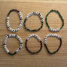 four bracelets with words and beads on them