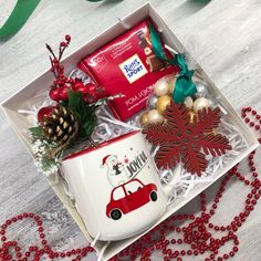 a christmas gift box with coffee mug, candy and decorations