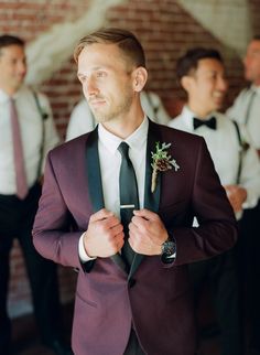 a man in a suit and tie standing next to other men