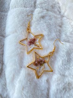 two gold stars with pink flowers on them are sitting on a white furnishing