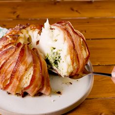 a white plate topped with bacon wrapped in cheese and broccoli next to a fork