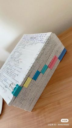 a piece of paper with colored sticky notes attached to it on top of a computer mouse