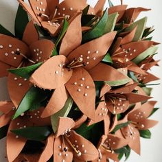 a close up of a wreath made out of brown paper with white dots on it