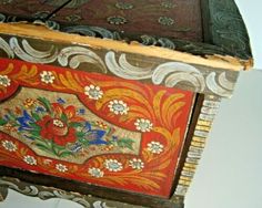 an ornate wooden box with flowers painted on it