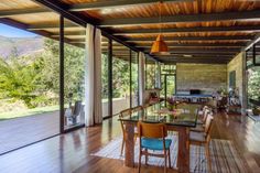 a dining room with glass table and chairs in front of sliding glass doors that open up to the outdoors