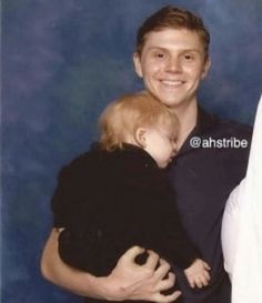 a man holding a baby in his arms