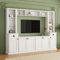 a living room with green walls and white entertainment center on the wall, built in bookshelves