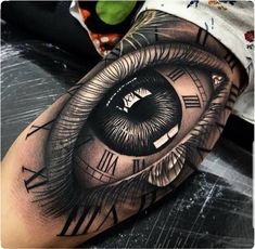 an eye with roman numerals tattoo on the arm