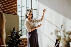 a woman standing in front of a window holding a cell phone