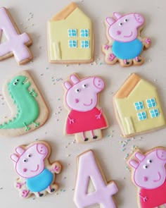 decorated cookies with peppa the pig and numbers for birthdays on a white surface