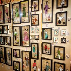 there are many pictures on the wall with children's clothes and dolls in them