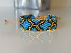 a blue and yellow beaded bracelet sitting on top of a table