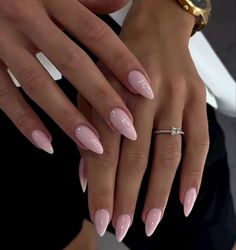 two hands with pink manies holding each other's fingers and wearing gold rings