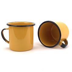 two yellow coffee mugs sitting next to each other on a white surface with black trim