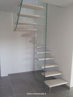 there is a glass stair case in the room with tile flooring and white walls