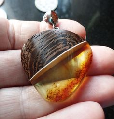 Striking Baltic Amber and Wood Silver Fitted Pendant. A very Modern Design, and a Stylish Statement Piece. Polished smooth on the front and sides, rough bottom right hand edge, adds to its charm. Amber is the Birthstone for Taurus and is considered a Lucky Stone Measures 3.50cm wide by 4.88cm the top of the bale. Weighs 6.9g. Shipping will be combined to reduce postage costs and includes a Gift Box made in England using 100% FSC Accredited and 100% Recyclable Board and Paper. Item will be dispat Taurus Birthstone, Lucky Stone, Baltic Amber, Right Hand, Pendant Necklaces, Phone Number, Cognac, Statement Pieces, Amber