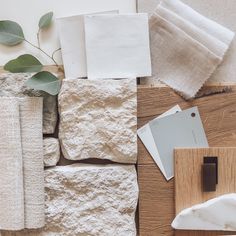 the table is covered with white linens, napkins, and other items that are laid out on top of each other