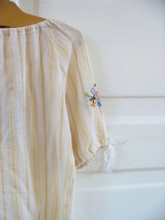 This vintage girl boho dress is such a unique find, and could not be any sweeter So much to love about it, and so many details: The comfortable fit, all of the hand sewn embroidery work, the adorable sleeves, etc etc. I am not sure if this is meant to be a dress for a younger one or a shirt for a little girl, but would work for either and could grow with your child. The interior tag seems like it is a shirt from Europe as it says 6-8, but please go by the measurements. It is in excellent conditi Vintage Cotton Peasant Top For Spring, Cotton Tunic Peasant Top For Beach, Spring Beach Peasant Cotton Top, Beige Cotton Peasant Top For Spring, Hippie Cotton Peasant Top For Beach, Cotton Peasant Top With Floral Embroidery For Beach, Cream Cotton Peasant Top For Spring, Spring Festival Cotton Peasant Top, Summer Hippie Cotton Peasant Top