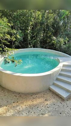 an outdoor swimming pool with steps leading up to it and trees in the back ground