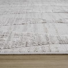 a white rug on top of a wooden floor