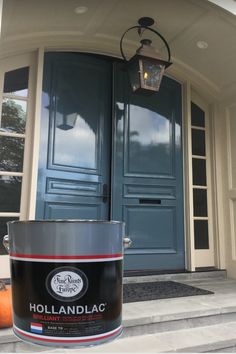 a paint can sitting on the steps in front of a blue door