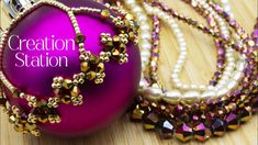 a purple ornament sitting on top of a table next to pearls and beads