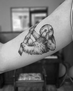 a black and white photo of a slotty bear tattoo on the right arm,