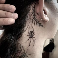 a woman with a spider tattoo on her neck