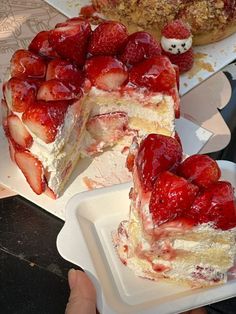 two slices of cake with strawberries on the top and one slice cut in half