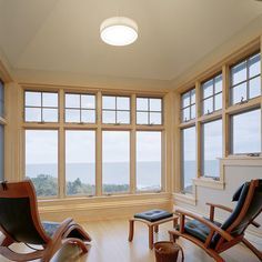 a living room filled with furniture and large windows